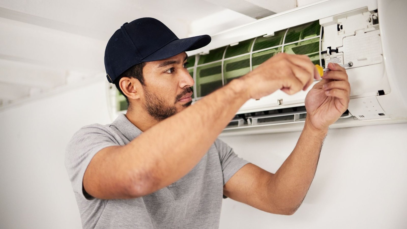 Air conditioner repair technician working on outdoor AC unit